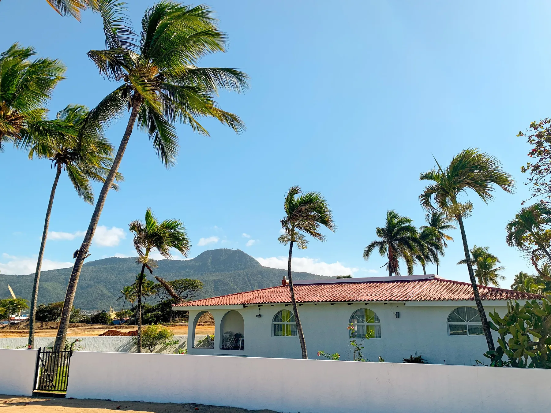 La villa vista desde el jardín, con las montañas detrás